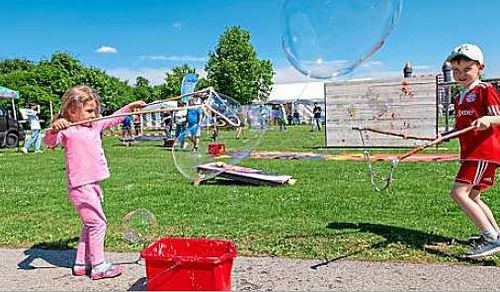 Zwei Kinder spielen mit Seifenblasen